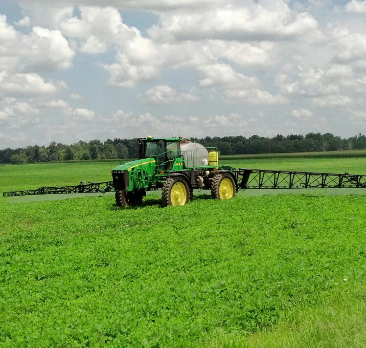 spreader applying fertilizer in field